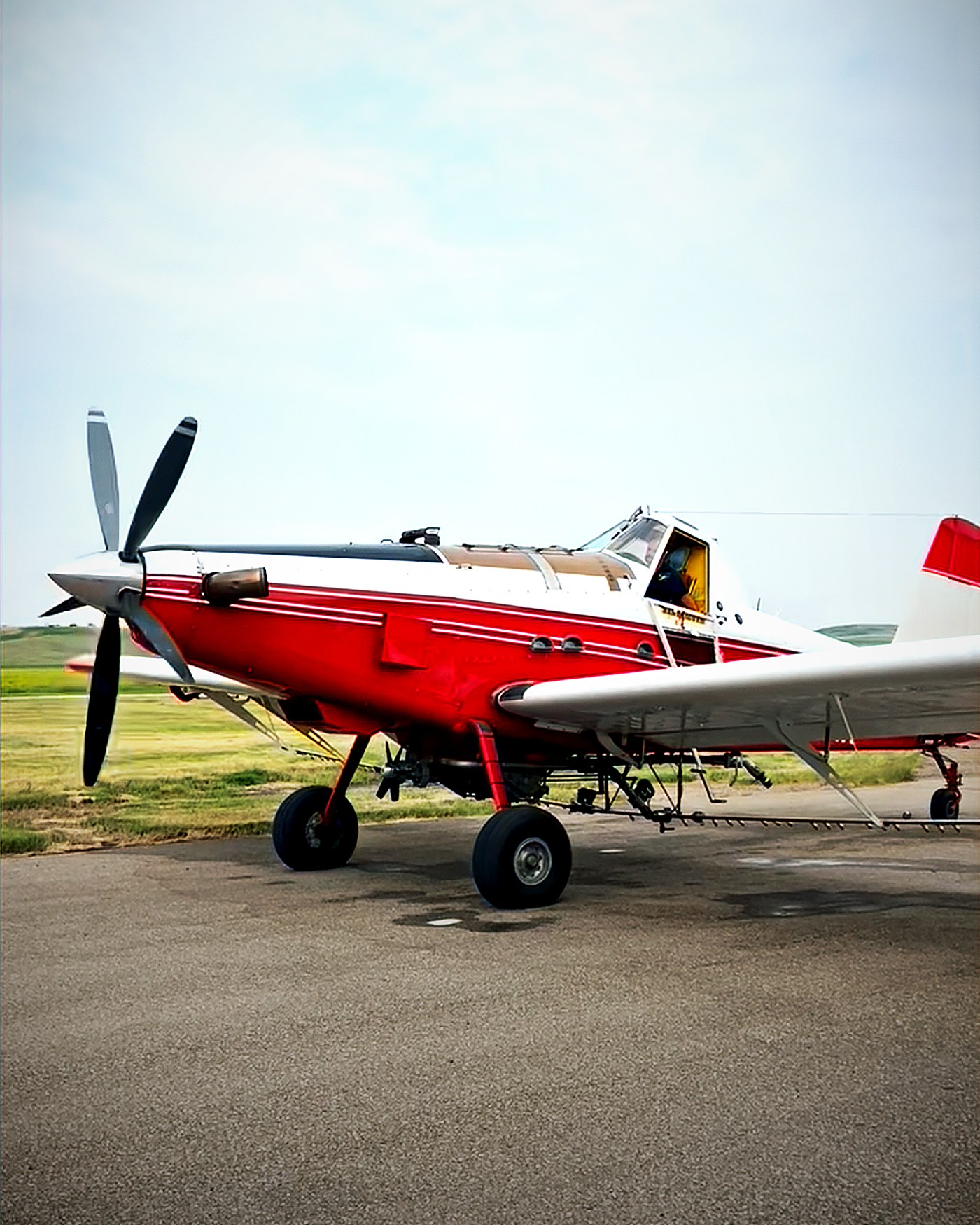 Red and white aerial application aircraft on the ramp
